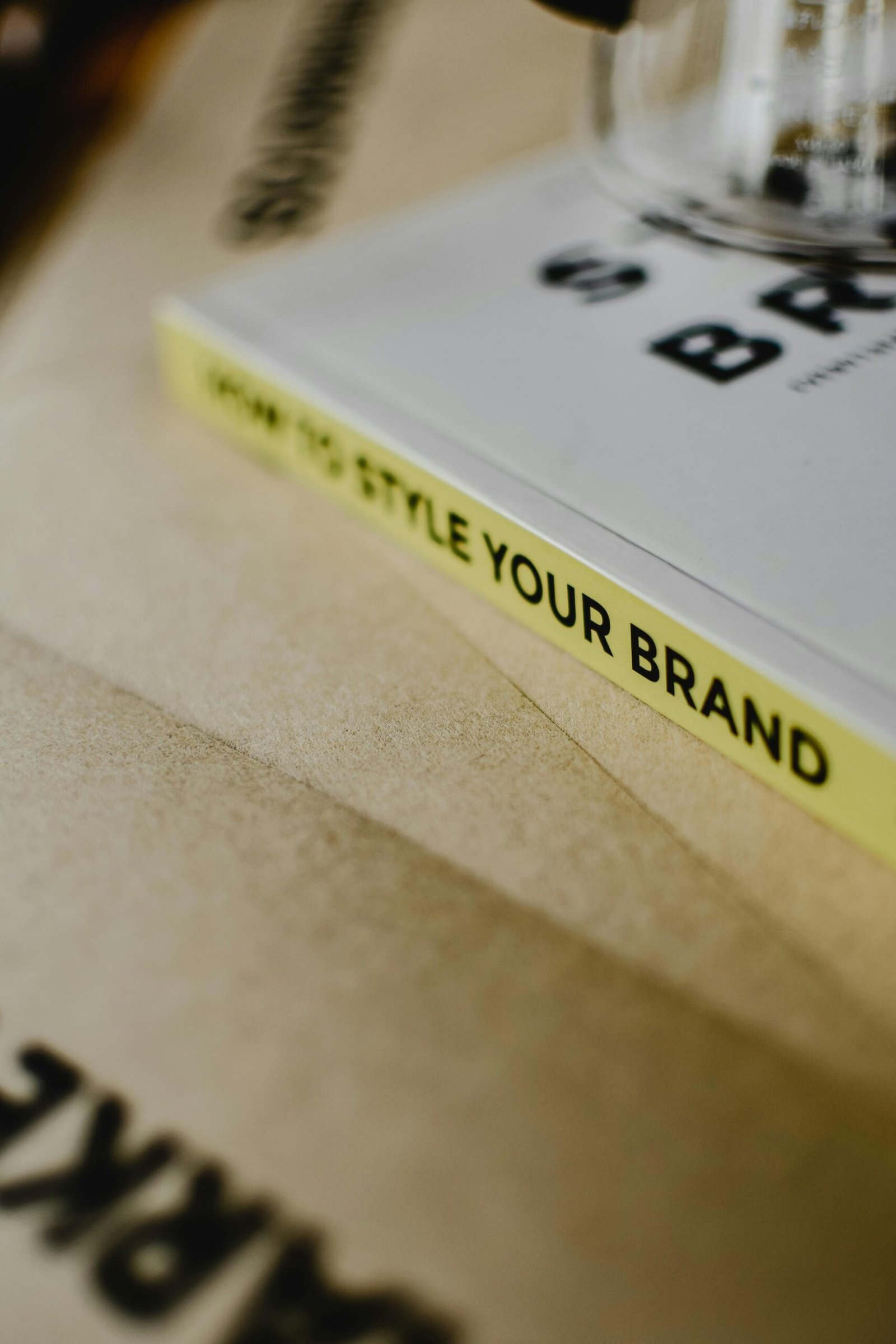 A close-up of a book titled "How to Style Your Brand" on a paper background.